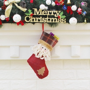 Chaussette de Noël rouge à carreaux avec Père Noël accrochée à la cheminée