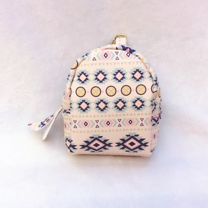 Macro view of mini canvas coin purse featuring pink ethnic geometric patterns and top ring