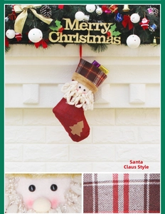 Détail macro de la broderie Père Noël et du tissu à carreaux sur une chaussette de Noël