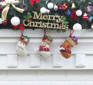 Détail de trois chaussettes de Noël en peluche avec Père Noël, bonhomme de neige et renne