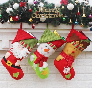 Three Christmas stockings with Santa, Snowman, and Reindeer hanging on a festive mantel