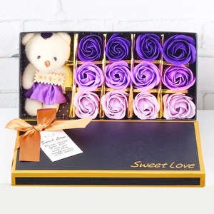 Detail of purple soap rose gift box with plush teddy bear and gold-trimmed black packaging