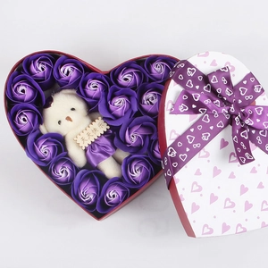 Macro shot of purple soap roses and a plush bear in a heart-shaped Valentine gift box