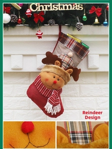 Detail view of 3D reindeer Christmas stocking with red scarf and plaid hat on white brick wall