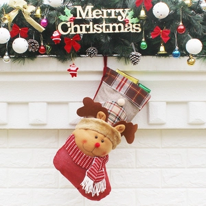 Festive Christmas stocking with reindeer doll hanging on a white brick fireplace mantle