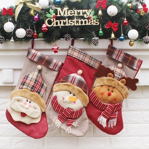 Three Christmas stockings with Santa, Snowman and Reindeer hanging on fireplace mantle