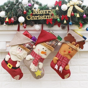 Détail de trois chaussettes de Noël festives avec motifs Père Noël, bonhomme de neige et renne