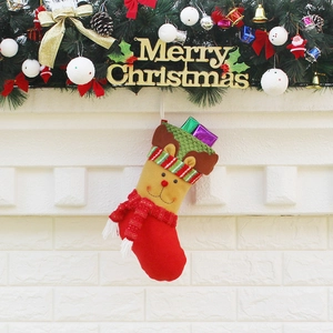 Christmas stocking with reindeer design hanging on a fireplace with festive holiday decor