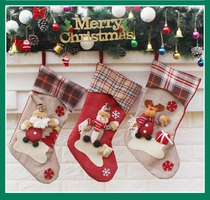 Close-up of three 3D Christmas stockings with Santa, snowman and reindeer on white wall