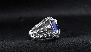 Macro shot of men's vintage dragon claw ring with a large blue zircon gemstone inlay