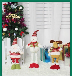 Three plush Christmas figurines Santa Snowman and Reindeer on a cozy holiday carpet