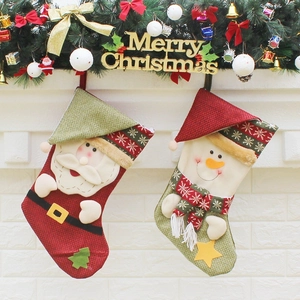 Christmas stockings with Santa and Snowman hanging on a festive wall decoration
