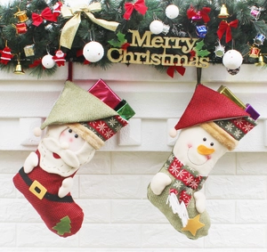 Detail of Christmas stockings with Santa and snowman motifs hanging on a festive mantelpiece