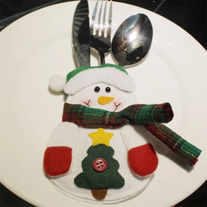 Snowman Christmas cutlery holder set featuring a green hat and red scarf on a white plate