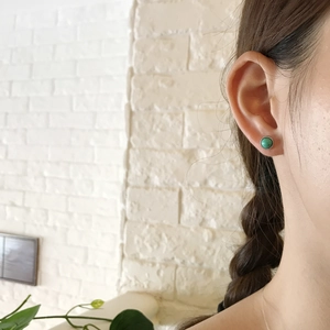Close-up of S925 silver turquoise stud earrings worn on a model for scale and detail