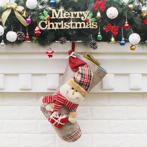 Chaussette de Noël bonhomme de neige en 3D en lin et tissu écossais sur une cheminée décorée