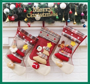 Three Christmas stockings with Santa, Snowman and Reindeer hanging on a festive fireplace