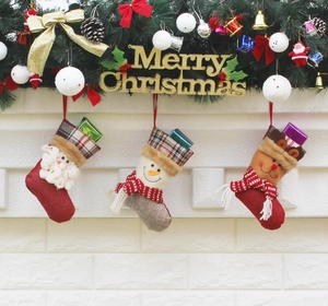 Detailed view of Santa, Snowman and Reindeer Christmas stockings hanging on a white wall