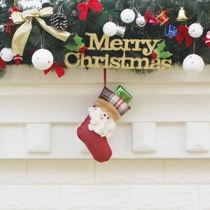 Red Christmas stocking with Santa 3D figure and plaid cuff hanging on a festive tree