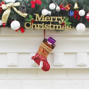 Christmas stocking with reindeer motif hanging on fireplace mantel with festive decorations