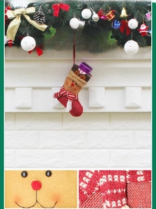 Detail of Christmas reindeer stocking with felt appliqué and embroidery on festive mantel