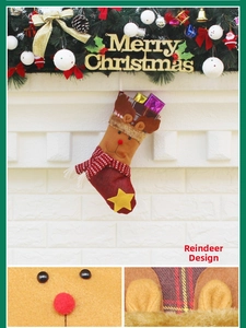 Détail d'une chaussette de Noël en peluche renne avec nez rouge et revers à carreaux