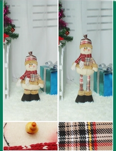 Détails macro d'un bonhomme de neige en peluche avec jambes extensibles et tissu à carreaux