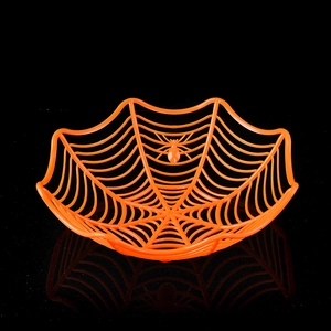 Detail of orange spider web fruit bowl featuring a central spider for Halloween party decor