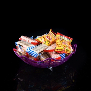Detail of purple spider-web fruit basket filled with snacks for Halloween party