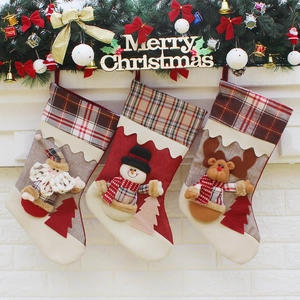 Three Christmas stockings with Santa, snowman and reindeer hanging on white brick fireplace