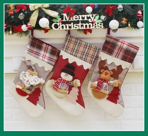 Three festive Christmas stockings with Santa, Snowman and Reindeer designs on a fireplace