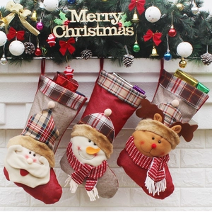 Three festive Christmas stockings with Santa, Snowman and Reindeer on white fireplace