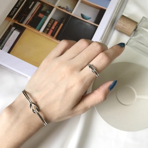 Detail of vintage knotted silver ring and bracelet set worn on a model's hand