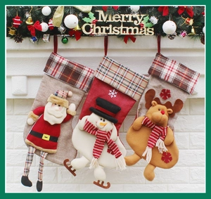 Détail de trois chaussettes de Noël avec Père Noël, bonhomme de neige et renne au foyer