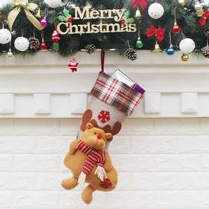 Chaussette de Noël en lin avec revers à carreaux et renne en peluche sur une cheminée