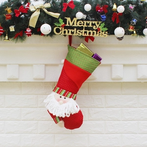 Knitted Christmas stockings with Santa figurines hanging on a festive mantle decoration