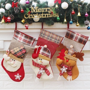 Three Christmas stockings featuring Santa, Snowman and Reindeer hanging on a fireplace
