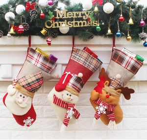 Three Christmas stockings with Santa, Snowman and Reindeer hanging on fireplace mantle
