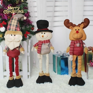Three festive Christmas plush figures with extendable legs in a cozy holiday home setting