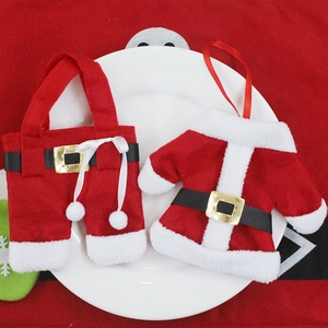 Christmas silverware holder set with Santa suit and pants on a white ceramic plate