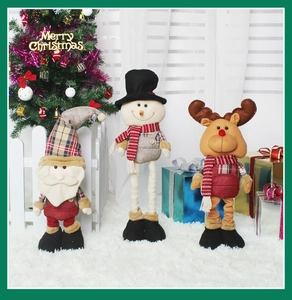 Three Christmas plush figures including Santa, snowman, and reindeer on a white rug