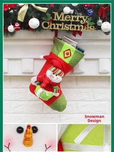 Detail of red and green Christmas stocking with a 3D snowman appliqué on a fireplace