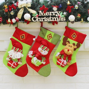 Three Christmas stockings featuring Santa, Snowman and Reindeer on a white brick wall
