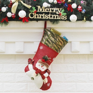 Red Christmas stocking with snowman hanging on a decorated festive fireplace