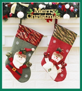 Detail of Santa and Snowman Christmas stockings hanging on a white brick fireplace