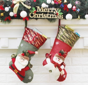 Detail of Christmas stockings with Santa and snowman hanging on fireplace mantle