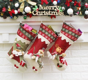Trois chaussettes de Noël tricotées avec Père Noël, bonhomme de neige et renne sur cheminée