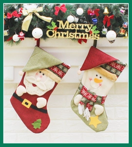 Detail of Christmas stockings with Santa and Snowman hanging on a festive fireplace mantel