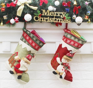 Detail of red and green Christmas stockings with Santa and Snowman hanging on a wall
