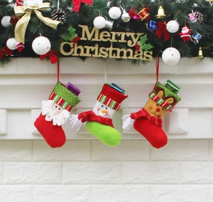 Detailed view of three knitted mini Christmas stockings with Santa Snowman and Reindeer